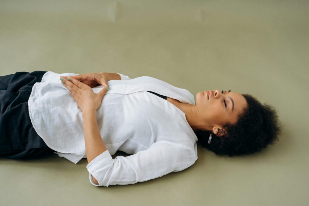 African American woman lying down with eyes closed, embodying relaxation and wellness. Perfect for wellness and mindfulness themes.