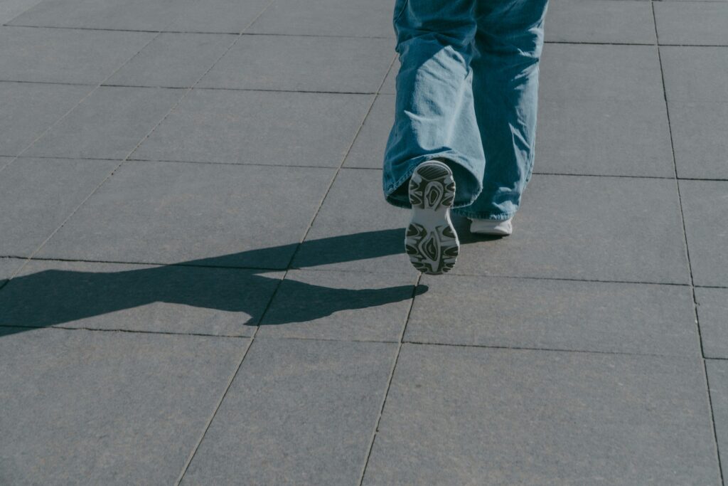 a person riding a skateboard down a sidewalk