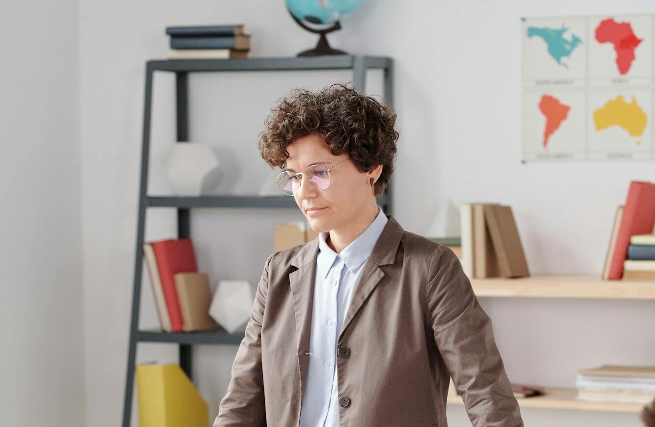 A teacher interacts with students in a modern classroom setting.