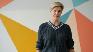 Woman with short blonde hair and a dark sweater