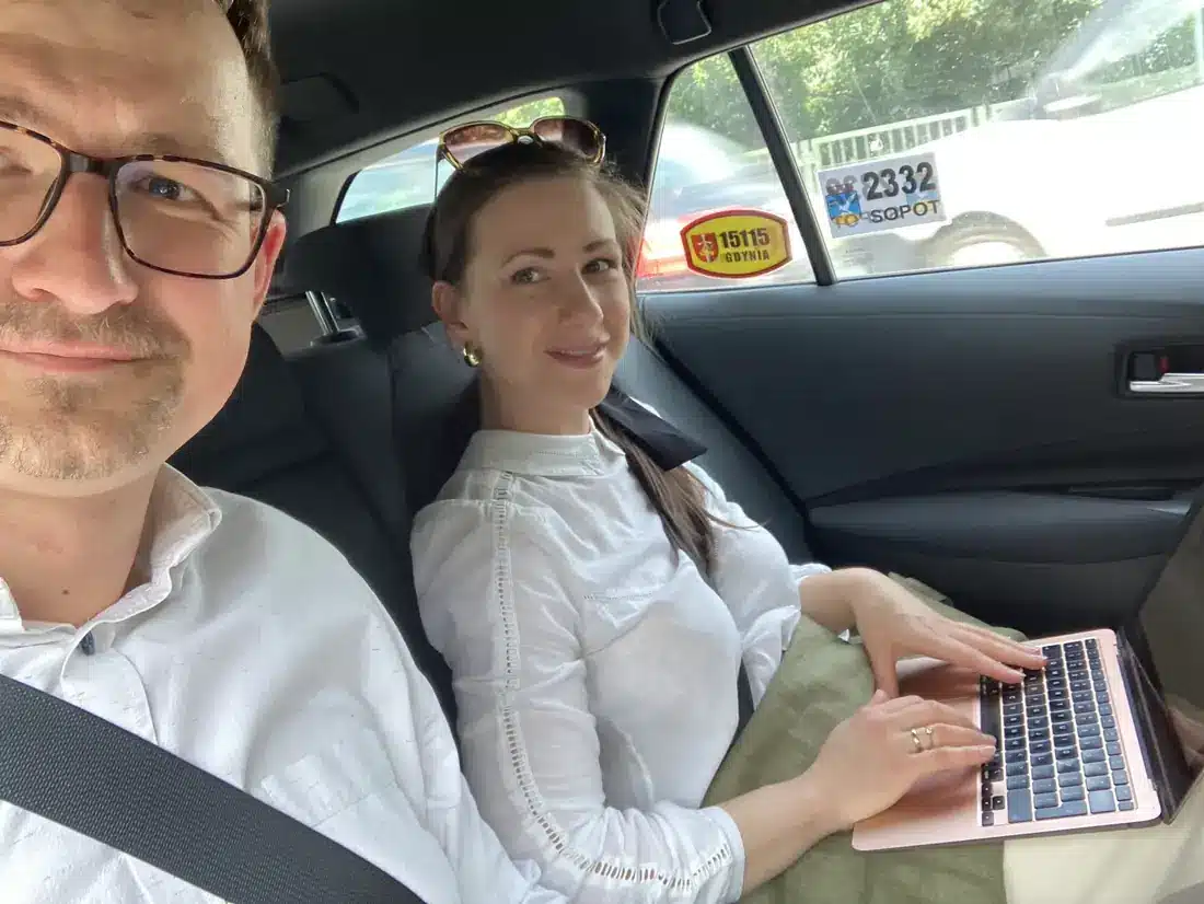 Dr Rafał Szewczyk i dr Marta Szewczyk w samochodzie, Marta pracuje na laptopie